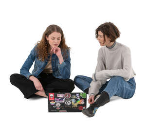 two cut out young women sitting on the ground and talking