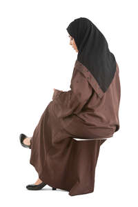 cut out muslim woman in a brown abaya sitting