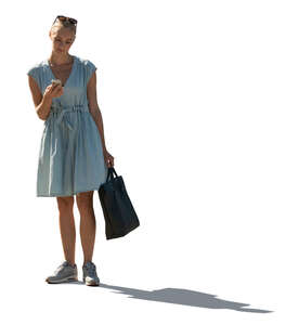 cut out backlit woman in a pale blue summer dress standing