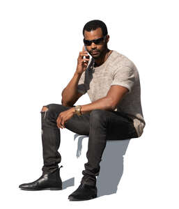 cut out black man sitting and talking on a phone