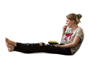 cut out woman sitting on the sofa and eating grapes