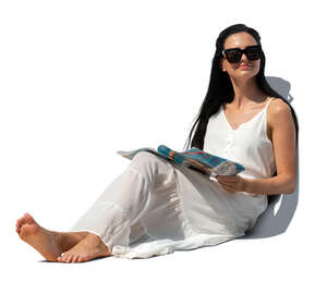 cut out woman in a casual white sitting on a sofa and reading a magazine
