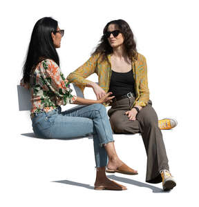 two cut out women sitting outside and talking