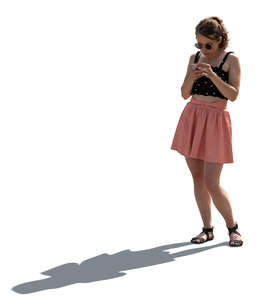 cut out backlit woman standing and texting