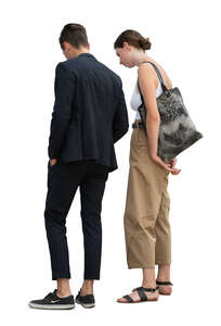 young man and woman standing and looking something on a table