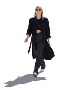 cut out backlit woman in a light black overcoat walking