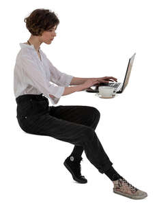 cut out woman sitting at a table with a laptop and drinking coffee