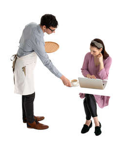 waiter serving coffee to a woman sitting at a table