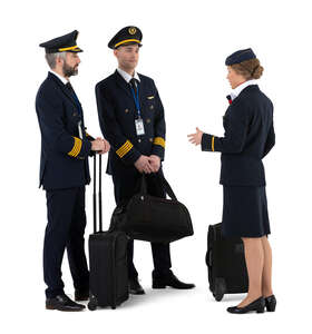 two cut out pilots and a female flight attendant with travelling bags standing and talking