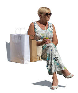 cut out woman with shopping bags sitting and drinking juice