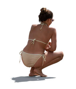 cut out backlit woman in bikini squatting