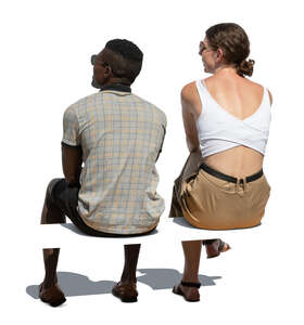cut out man and woman sitting outside seen from back angle