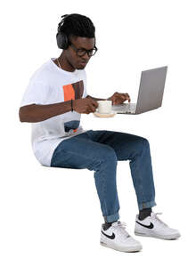 cut out man sitting at a cafe with laptop and headphones