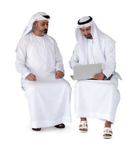 two cut out arab men wearing emirati kandoras sitting and discussing