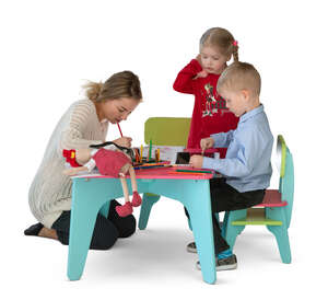 two cut out kids and a woman drawing at a kids table