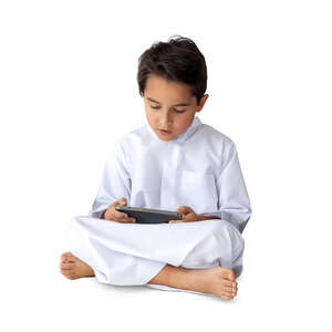 cut out little arab boy sitting and reading from tablet