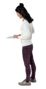 cut out woman standing at a counter and looking at a tablet