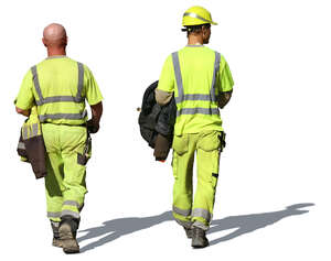 two workmen in work clothes walking in the sunlight