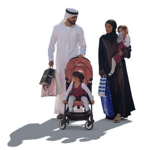 backlit arab family with shopping bags walking