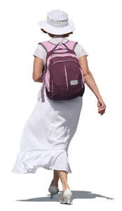 woman in a white dress carrying a backpack walking