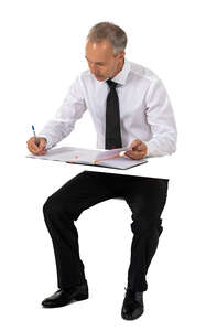 cut out businessman sitting at a table and writing