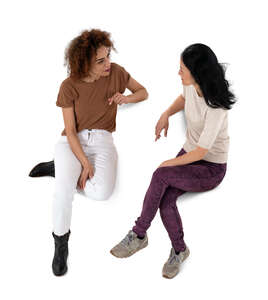 two cut out women sitting and talking seen from above