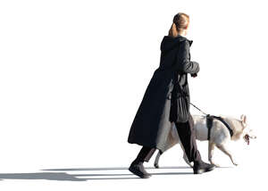 cut out woman in a black long coat walking a dog