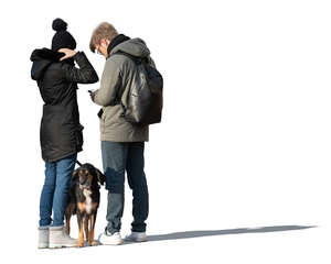 two cut out people with a dog standing in winter
