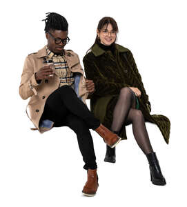 two cut out people wearing light jackets sitting