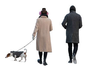 two cut out people walking a dog in winter