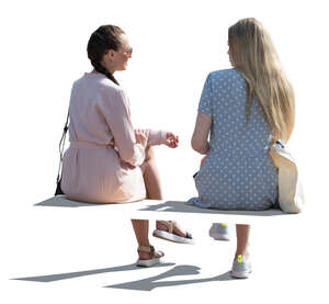 two cut out backlit women sitting and talking