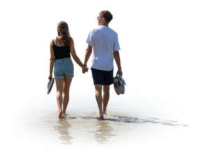 cut out man and woman walking hand in hand barefoot on the beach
