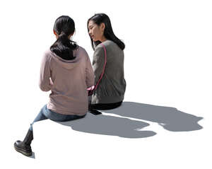 two cut out backlit women sitting and talking