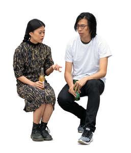 two cut out asian people sitting and drinking soft drinks