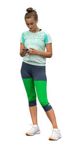 cut out woman in sports clothes standing and looking at a phone
