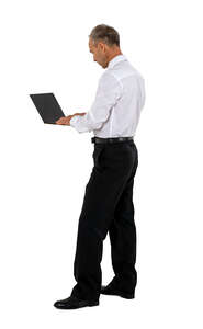 man standing and working with a laptop at a counter