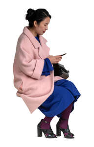 cut out woman in a pink overcoat sitting