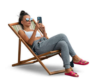 cut out woman lying in a garden chair and texting