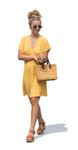 cut out woman in a yellow summer dress walking