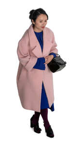 cut out asian woman in a pink overcoat walking seen from above
