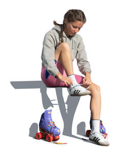 cut out woman sitting and taking off roller skating shoes