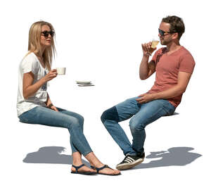 two cut out people sitting in an outdoor cafe on a sunny day