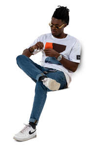 cut out man sitting and attatching headphones to his phone
