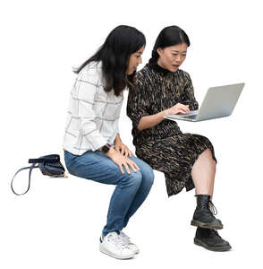 two cut out asian women sitting and looking smth from a computer