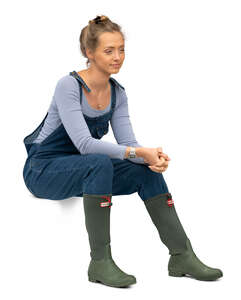 cut out woman in wellies and denim dungarees sitting