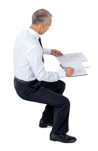 cut out office worker sitting and writing seen from above