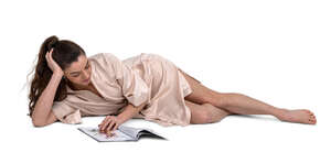 cut out woman in a silky bathrobe lying on a bed and reading