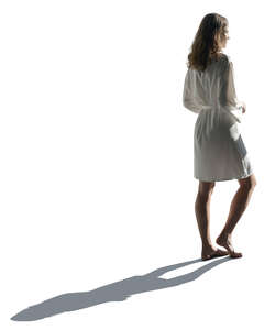 cut out backlit woman in a silky bathrobe standing
