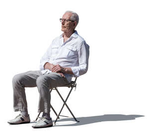 cut out elderly man sitting outside in the sunlight