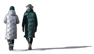 two cut out sidelit women in winter coats walking